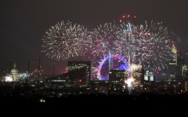 倫敦的「倫敦之眼」上空有璀璨的煙火秀。（路透）
