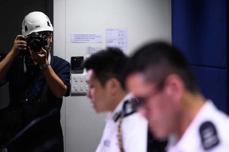 香港記者協會今日在港警記者會發起抗議行動，戴頭盔譴責「警方濫用武力，阻礙記者採訪」。（法新社）