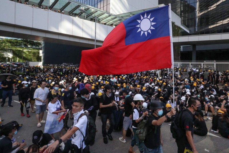 民調顯示，港人贊成台灣獨立的比率大幅上升。圖為香港反送中遊行中出現高舉中華民國國旗的畫面。（歐新社）