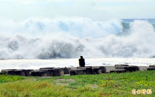 A person sits on breakwater blocks in Taitung County yesterday and watches the high waves caused by Typhoon Mangkhut as they hit the coast.
Photo: CNA
A person sits on breakwater blocks in Taitung County yesterday and watches the high waves caused by Typhoon Mangkhut as they hit the coast.
Photo: CNA