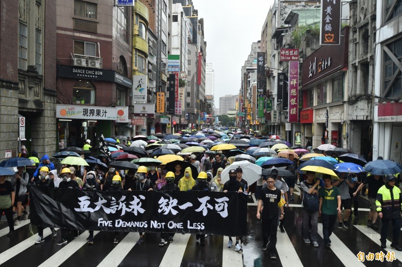 「929台港大遊行：撐港反極權」今天下午在台北冒雨登場，在「五大訴求，缺一不可」的布條下向前行進。（記者塗建榮攝）