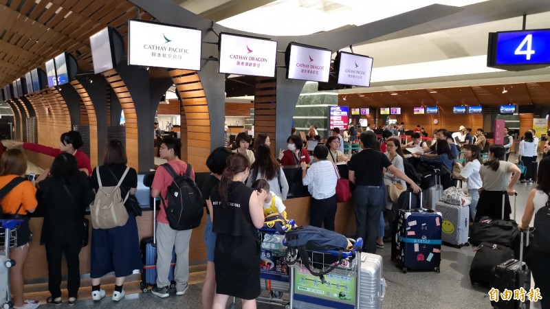 香港機場緊急關閉，台港航班陸續取消，桃園機場出境櫃台擠滿旅客，目前部分業者明晨航班也宣布取消，仍不知何時恢復。（記者姚介修攝）