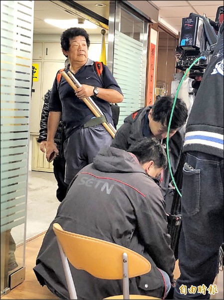 藍天行動聯盟秘書長楊思聖手持兩支棍棒嗆聲要打三立記者，沒發現三立記者就在他面前。（記者陳昀攝）