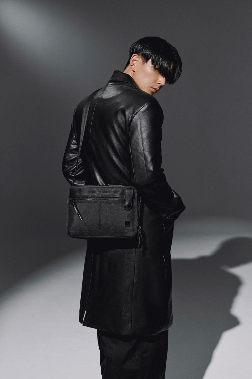 JUN身揹PORTER INTERNATIONAL NEW HEAT JET BLACK「重塑經典 雙層斜肩包」，包款低調簡約，獨具魅力，提供都市潮人全新搭配選擇。