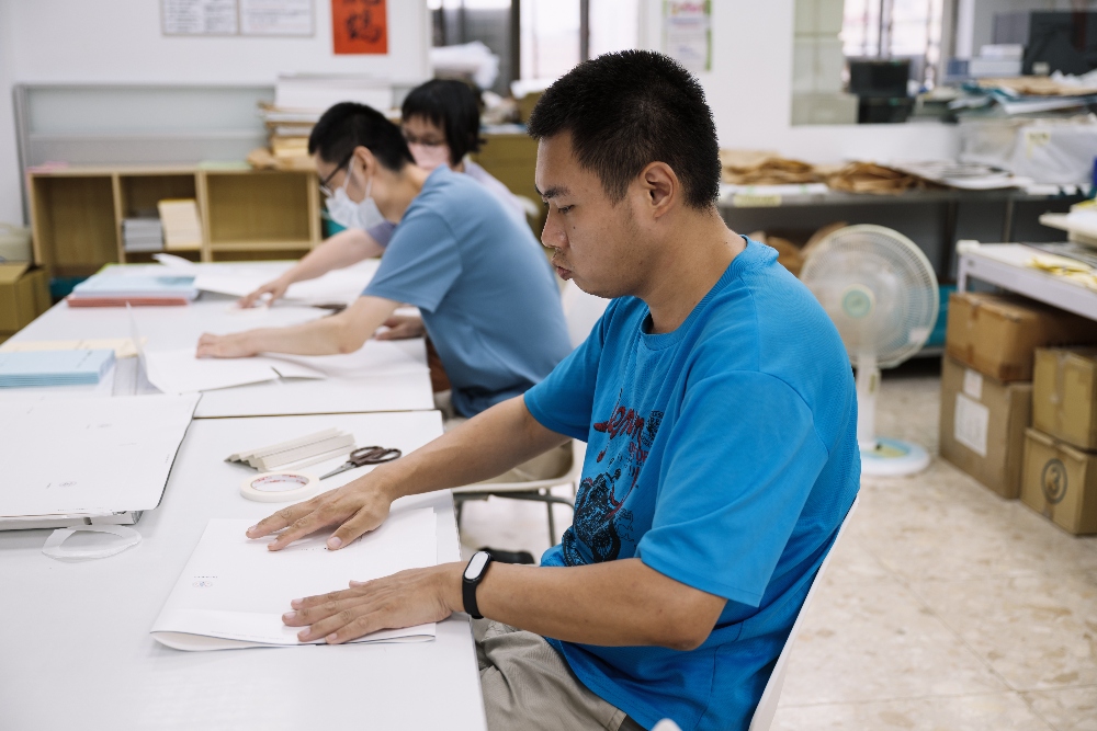 昱全仔細對好折角。(圖片提供/庇護工場)