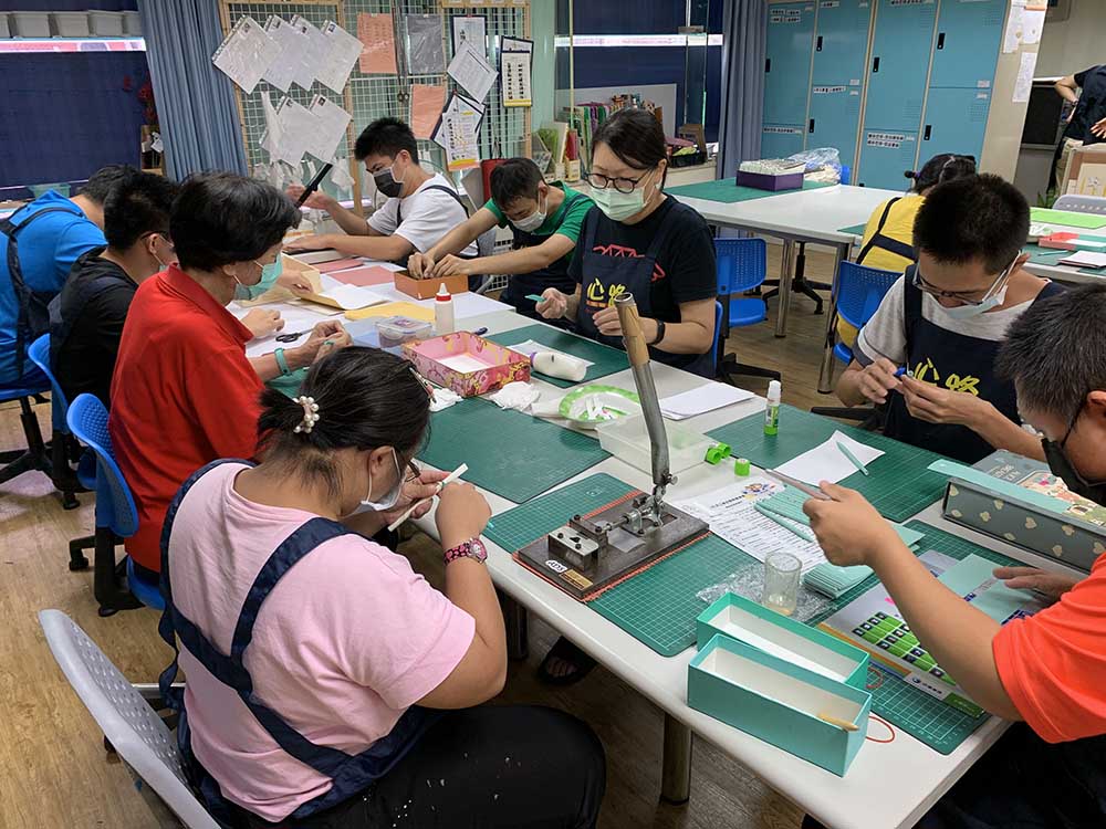 全國最多社區作業設施(小作所)服務對象製作紙捲筆。(圖片來源：高雄市政府社會局)