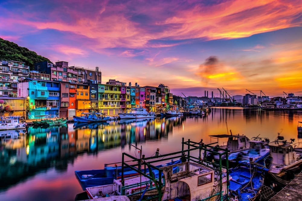 正濱漁港夕陽染上天空色彩，倒映在水面的彩色屋更添浪漫。（圖／北海岸及觀音山國家風景區管理處提供）