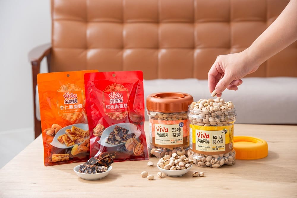 年節團聚時刻，萬歲牌經典桶裝堅果八款口味適合共享，搭配核桃南棗糕與杏仁鳳梨糕，為年節茶點增添層次與團聚儀式感。（圖／萬歲牌提供）