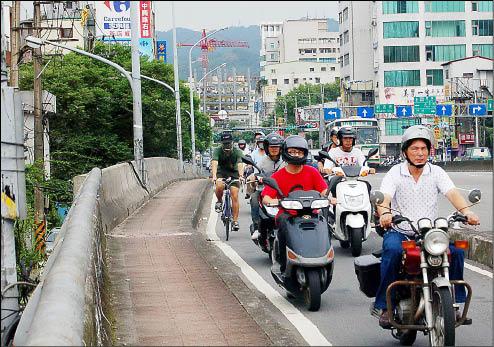 秀朗橋尖峰時間車水馬龍，原本狹窄的機慢車專用道，必須同時擠下單車與機車族，對兩個族群而言都相當危險。                                                                                                                                （記者邱紹雯攝）