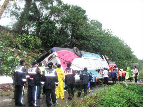 遊覽車翻覆在國道邊坡下側健行路上。（記者羅正明攝）