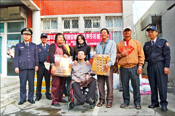 中醫師吳財秀（圖中坐輪椅者）克服身體不圓滿，全力彌補他人經濟缺憾。（記者林國賢攝）