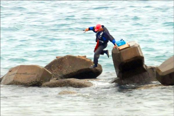 美崙溪出海口的釣客在消波塊上跳來跳去，險象環生。（記者游太郎攝）