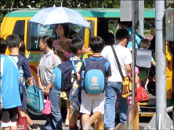 不少安親班使用娃娃車違規載運七歲以上兒童，讓身材高壯的小學生擠在狹小座位內。（靖娟基金會提供）