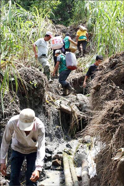 基督教長老教會昨召青年軍以人工接駁，把柴油、發電機及泡麵等物資送到阿里山鄉南邊3村境。（記者謝銀仲攝）