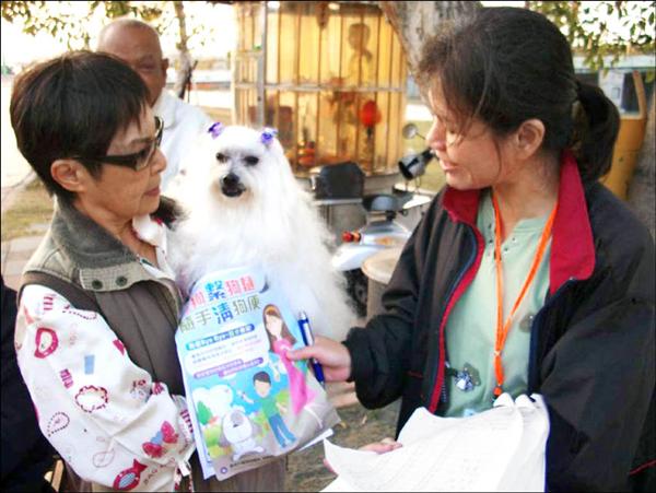 環保局人員宣導遛狗繫狗鍊、清狗便，明年全面開罰。<br>（記者蔡文居攝）