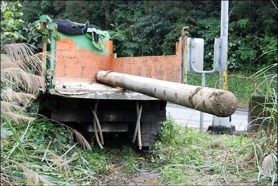 簡嫌昨天開著怪手把電桿搬上貨車，露出一大截在車外，引來警察注意。（記者楊培華攝）