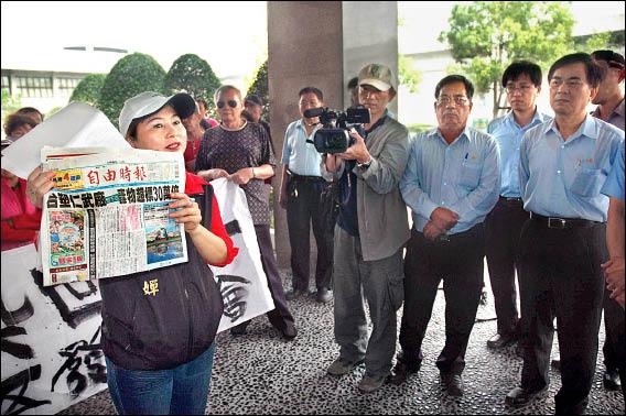 台塑仁武廠廢水滲漏，竟然早在九十一年即發生！昨天上百名住在台塑仁武廠附近的中華社區居民前往抗議，村長徐翠嬋（左）拿著報紙有關地下水污染超標三十萬倍的報導，控訴台塑仁武廠長期毒害村民。（記者方志賢攝）