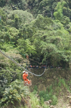 阿里山鄉山美及新美等部落對外溪底便道遭大雨沖毀，造成數百人受困，縣消防局人員特地到山美村組架橫越曾文溪流籠，解決受困村民交通問題。（記者謝銀仲攝）