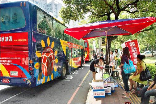 和欣客運在黎明路設站，旅客在人行道上的簡易遮陽棚下候車。（記者張協昇攝）