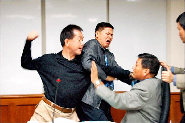 台中市議會昨天差點引爆「全武行」，議員黃錫嘉（左）不滿王岳彬（右）對他拍桌，拉住王岳彬的領帶，右手握拳，另一位議員林汝洲（中）緊急勸阻，黃錫嘉的右手並未「搥下」。（記者唐在馨攝）