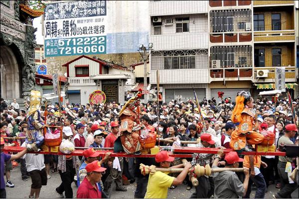 蜈蚣陣由大人扛行，神童坐在上面。（記者楊金城攝）