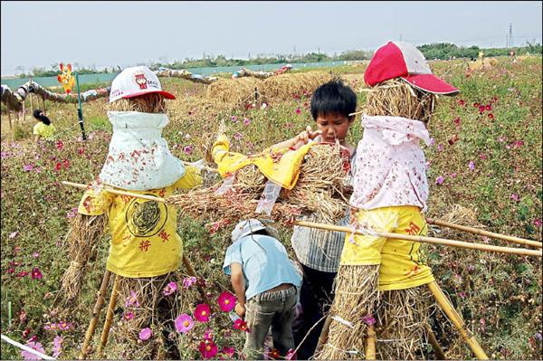 為逼真呈現迎媽祖的熱鬧氣氛，學童在稻草轎伕身上灑炮屑。（記者陳燦坤攝）