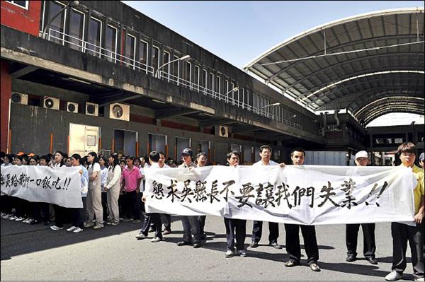 爭議三十年的義美工廠佔用南崁溪河川地問題，桃園縣政府昨上午強制拆除，義美員工站在義美食品安全研究室（後方建物二樓，紅框處）前拉布條抗議。（記者李容萍攝）