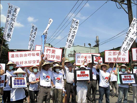 民眾昨天聚集三峽瀝青廠高舉布條抗議，要市府積極解決空汙問題。（記者謝佳君攝）
