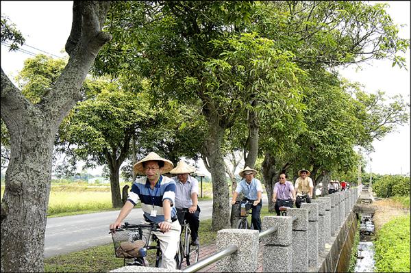 白河竹門社區入圍今年全國十大環保模範社區決選，昨天環保署評鑑小組實地騎單車走訪竹門綠隧等地。（記者楊金城攝）