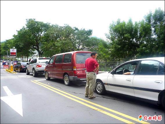 碧潭風景區假日停車位一位難求，不少駕駛人枯等不到車位，乾脆下車跟朋友聊天，打發時間。（記者潘杏惠攝）