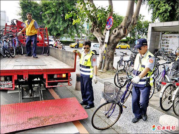 交警大隊在大學路人行道拖吊違停的單車。（記者王俊忠攝）