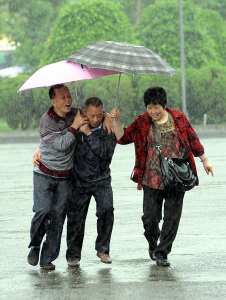 受到鋒面影響，明後兩天各地都會出現大雨或豪雨，圖為民眾撐傘觀光。（本報資料照，記者方賓照攝）