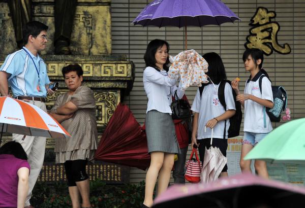 雙北市昨皆臨時宣布停班停課，讓許多家長疲於奔命抱怨不已，冒雨趕到學校接小孩。（本報資料照片，記者簡榮豐攝）