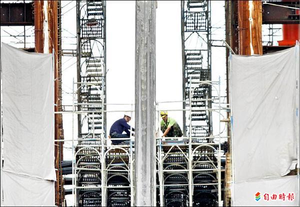 台中市一處高樓建築工地的工人在悶熱中工作，檢查安全措施，做好防颱防雨準備。（記者詹朝陽攝）