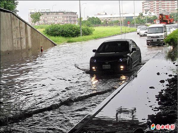 嘉義市北港交流道下方道路積水達30公分，車輛涉水通過，叫苦連天。（記者丁偉杰攝）