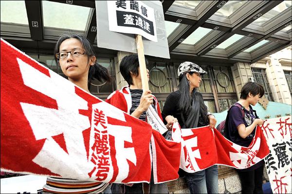 台東美麗灣渡假村經法院判決定讞環評、建照無效，但業者仍意圖闖關，昨日環團帶著布條前往該集團台北的美麗信酒店前，要求企業放棄開發。 （記者叢昌瑾攝）