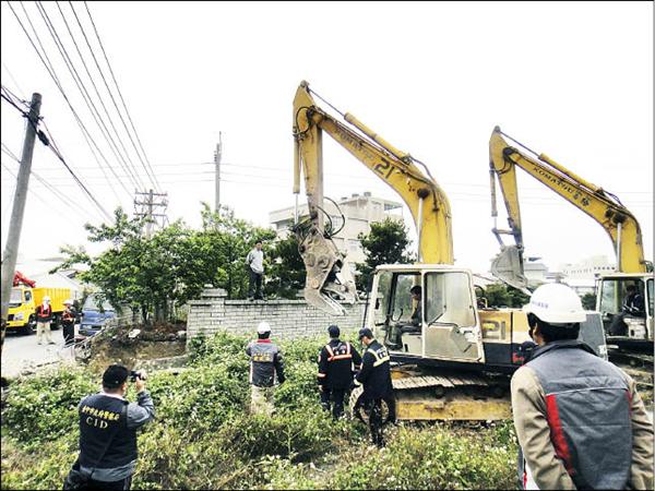 三和路三百五十四巷邱姓地主兒子，一度站在圍牆上試圖阻止怪手拆牆。（記者謝鳳秋翻攝）