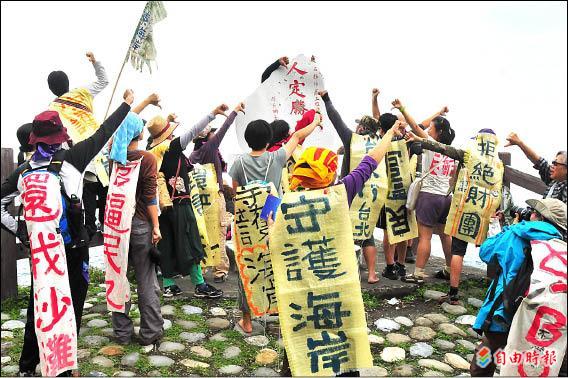 「不要告別東海岸」徒步行動昨走到豐濱鄉，在台11線62.1K「人定勝天碑」前，比出「遜斃了」手勢，呼籲政府揚棄舊思維，要友善環境。（記者花孟璟攝）