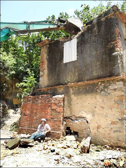 陪伴鼓山哨船頭里民的建築「舊槍樓」，面臨拆除命運，來台八年的法國留學生藍傑鴻靜坐，企圖肉身護樓，迫使怪手作業中斷。（照片由打狗文史再興社提供）