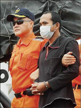 「特宏興368號」船上的印尼籍漁工被押解下船。（記者楊宜敏攝）