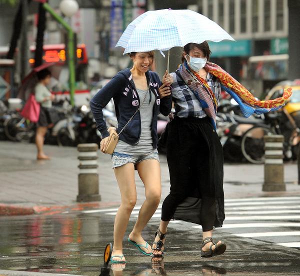 中度颱風菲特來襲，台北市今日風雨較小時，民眾仍出門上街。（記者方賓照攝）
