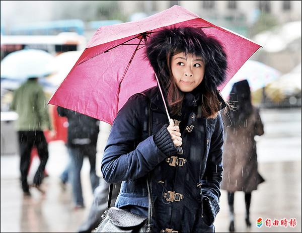 昨日又濕又冷，台北街頭的行人穿著厚重外套禦寒。（記者廖振輝攝）