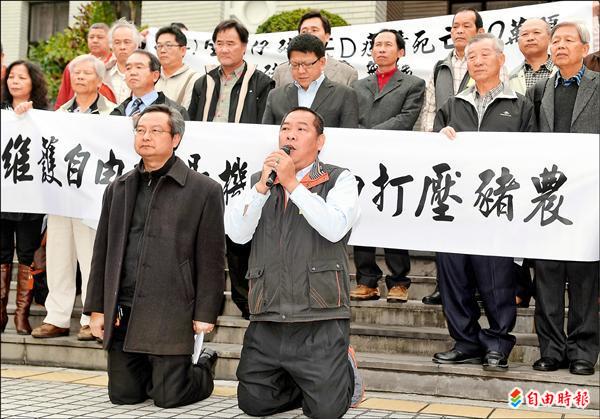 中華民國養豬協會理事長楊冠章（左）與常務理事潘連周（右）兩人下跪，強烈反對政府降低關稅進口豬肉，打壓豬農。（記者朱沛雄攝）