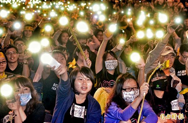 學生團體昨天退出議場後，在濟南路上舉行晚會，參與民眾拿出手機揮舞，高聲合唱太陽花學運主題曲「島嶼天光」。（記者王藝菘攝）