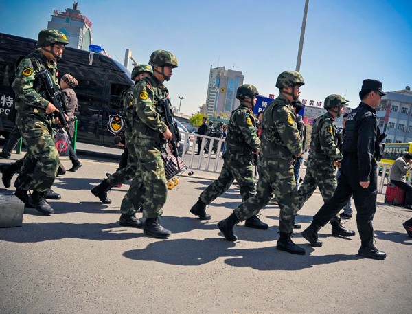 圖為新疆烏魯木齊火車南站，武警荷槍實彈巡邏。（資料照，中央社）