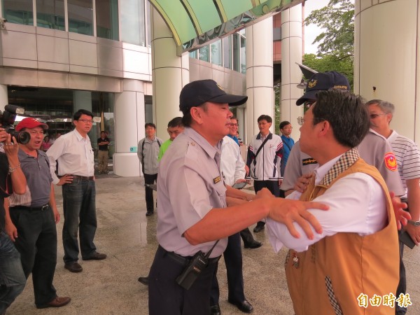 陳昌輝（右）與謝龍介（左筆上衣者）隔著警方互嗆。（記者蔡文居攝）