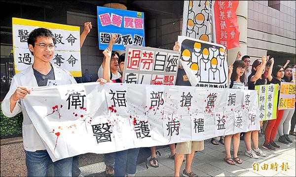 醫師勞動條件改革小組與黑島青、台灣醫療改革基金會等團體舉標語抗議，批衛福部不務正業。（記者廖振輝攝）