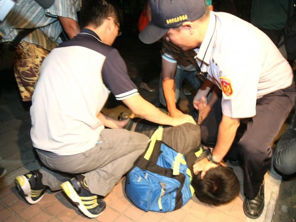 中國國台辦主任張志軍昨訪台第3天，學生丟擲白漆和冥紙襲擊張志軍車隊，遭警方壓制。（記者黃志源攝）