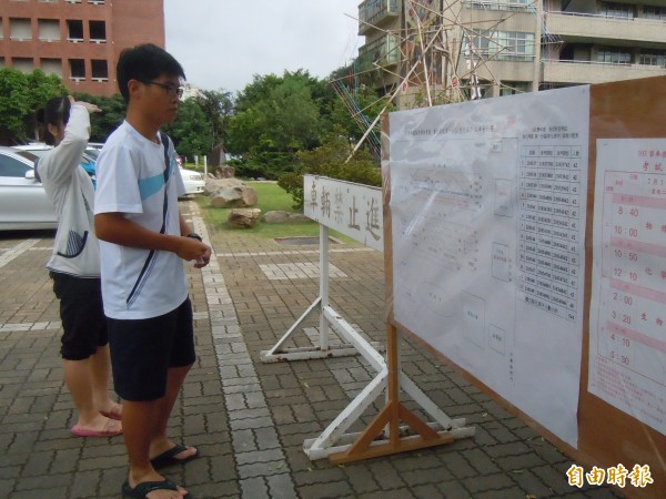 大學指考明天登場，今天不少考生前往試場確認座位，考場在彰中的考生，在試場平面圖找到試場位置後，進到試場試坐自己的座位。（記者張聰秋攝）