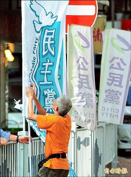 香港七一大遊行今登場，工作人員昨在遊行出發地點「維多利亞公園」懸掛政黨旗幟，為遊行做準備。（記者羅沛德攝）